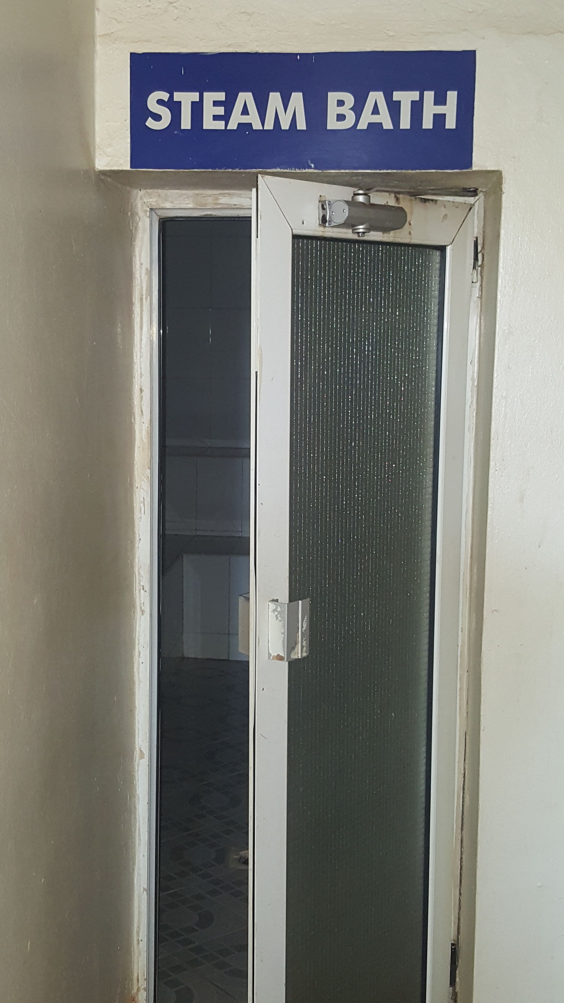A door with a sign above it reading "STEAM BATH".