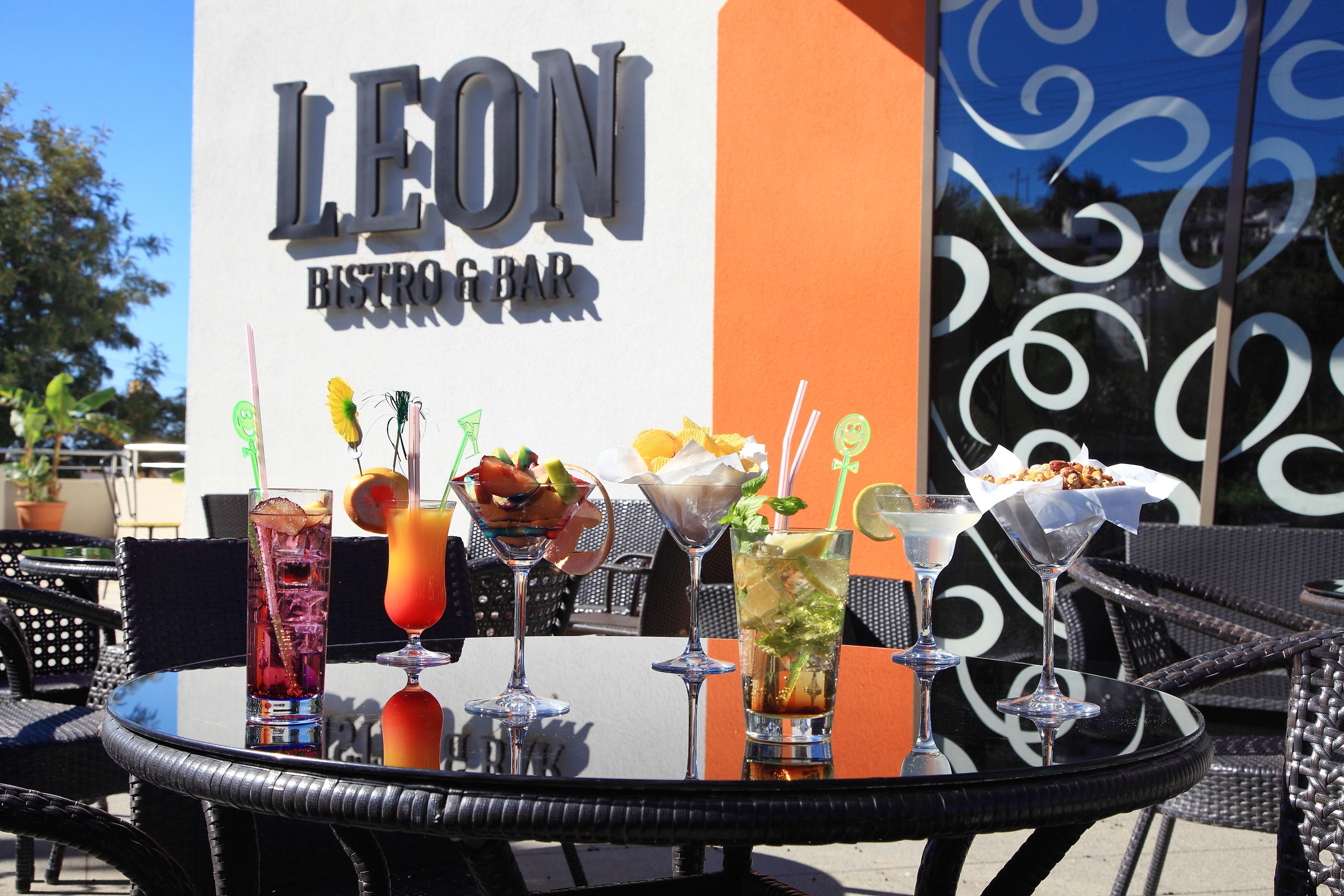A table with various drinks and a sign for Leon Bistro Bar.