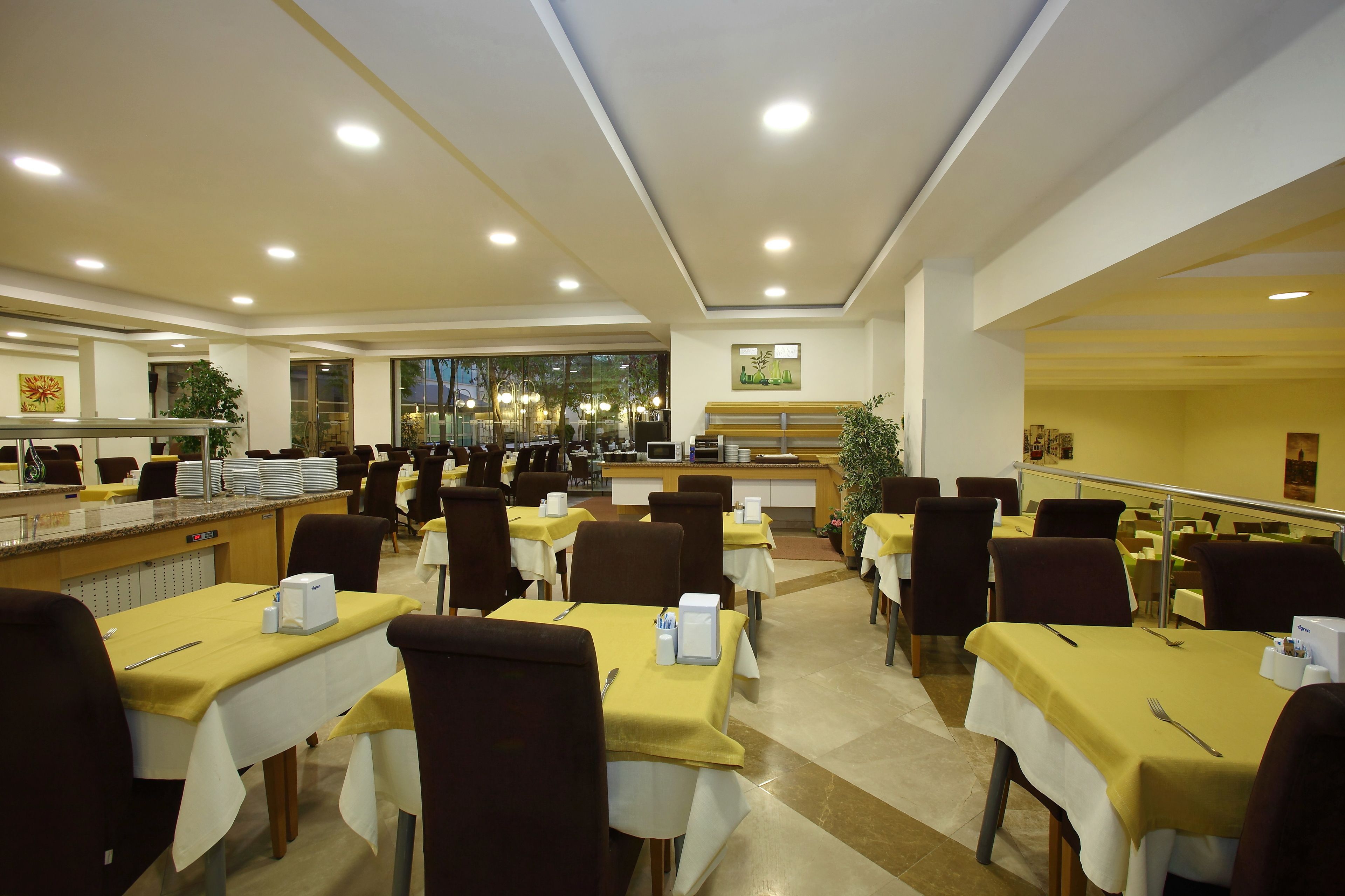 A spacious dining area with multiple tables, chairs, and a buffet counter.