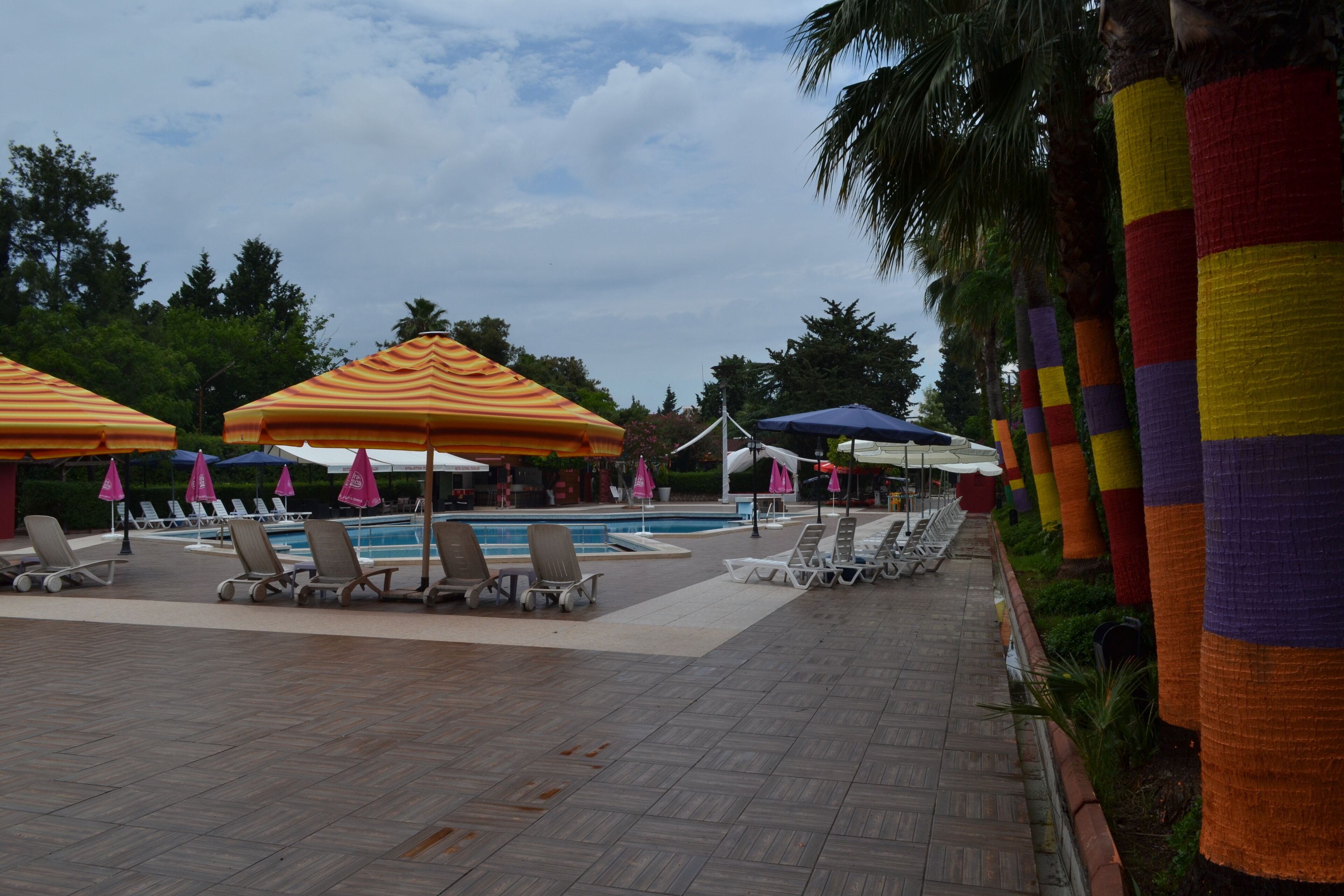 A poolside area with lounge chairs and umbrellas.