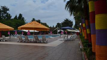 A poolside area with lounge chairs and umbrellas.