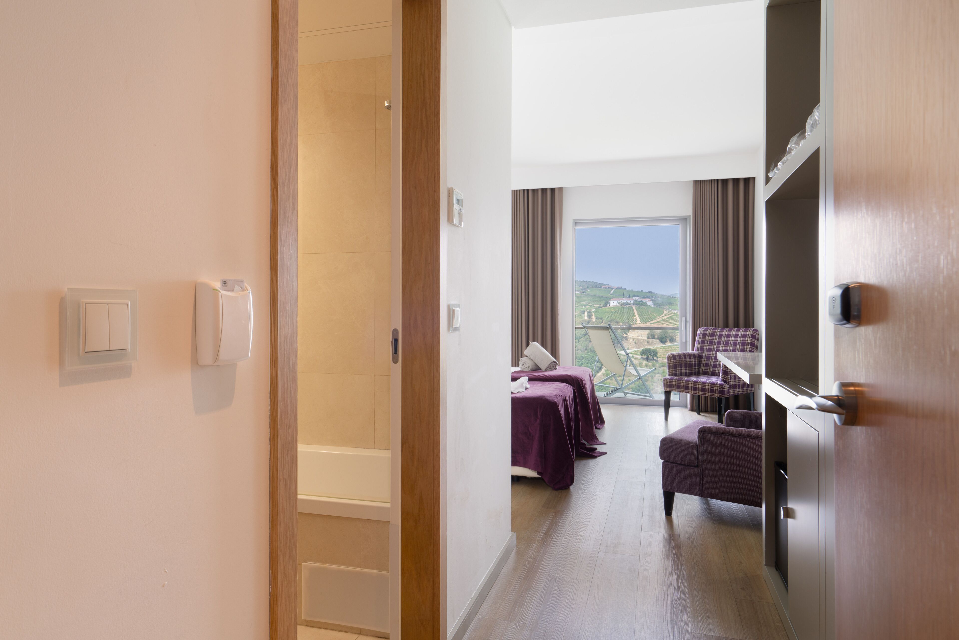 Habitación de hotel con vista, una cama, una silla y un escritorio.
