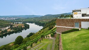 A hotel with a stone facade, a view of a lake, and surrounding greenery. - Delfim Douro Hotel (Lamego)