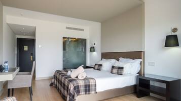 Una habitación de hotel moderna con una cama grande, un escritorio y una silla.