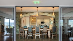 A dining area with a stone arch, wooden chairs, and hanging light fixtures. - Delfim Douro Hotel (Lamego)