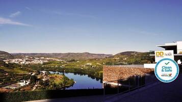 A hotel with a view of a lake and surrounding hills.