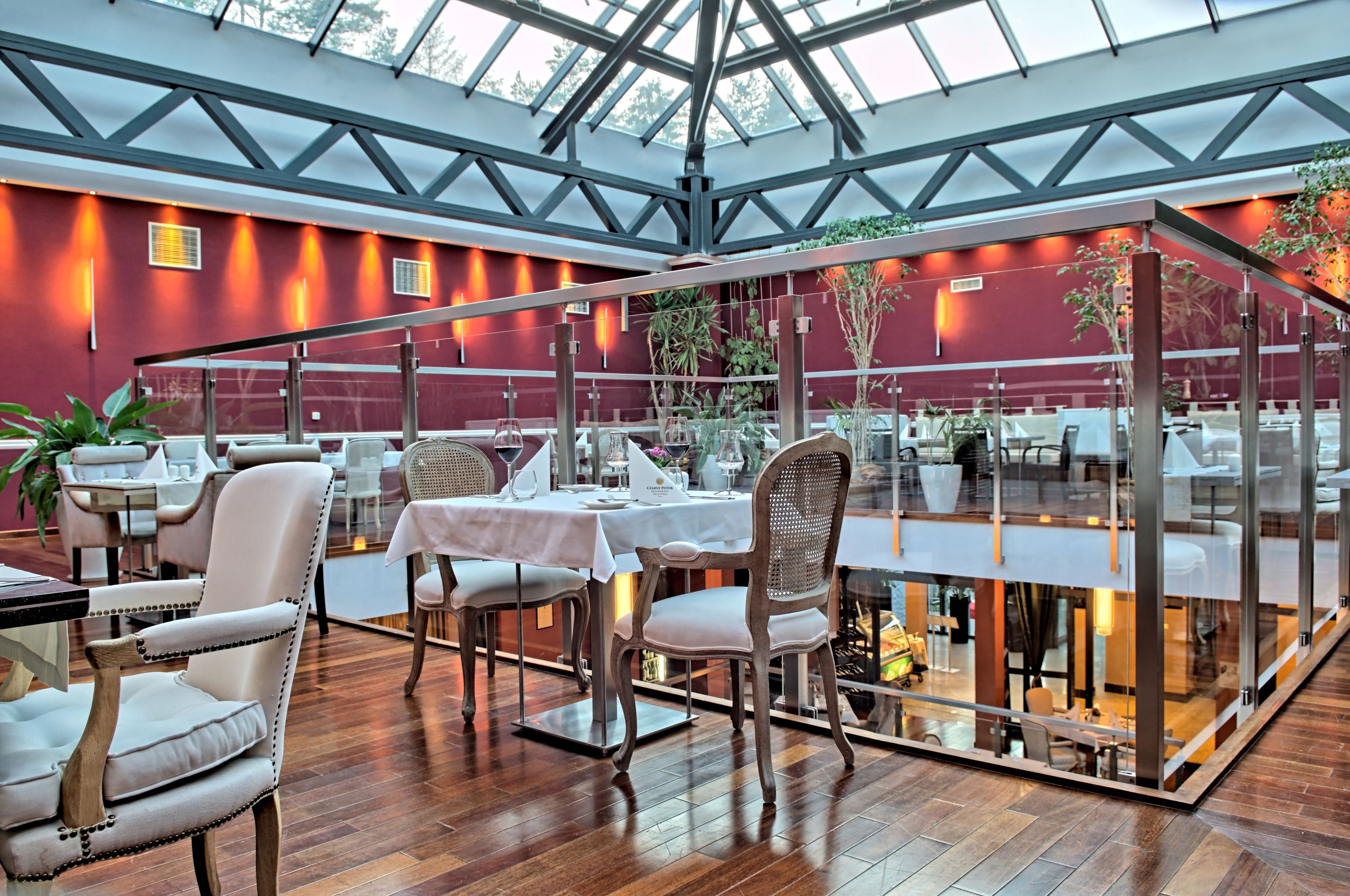 Un restaurant doté d’une véranda en verre, d’un plancher en bois et de murs rouges.