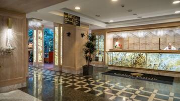 A lobby with a checkered floor, a reception desk, and a sign indicating the lobby area.