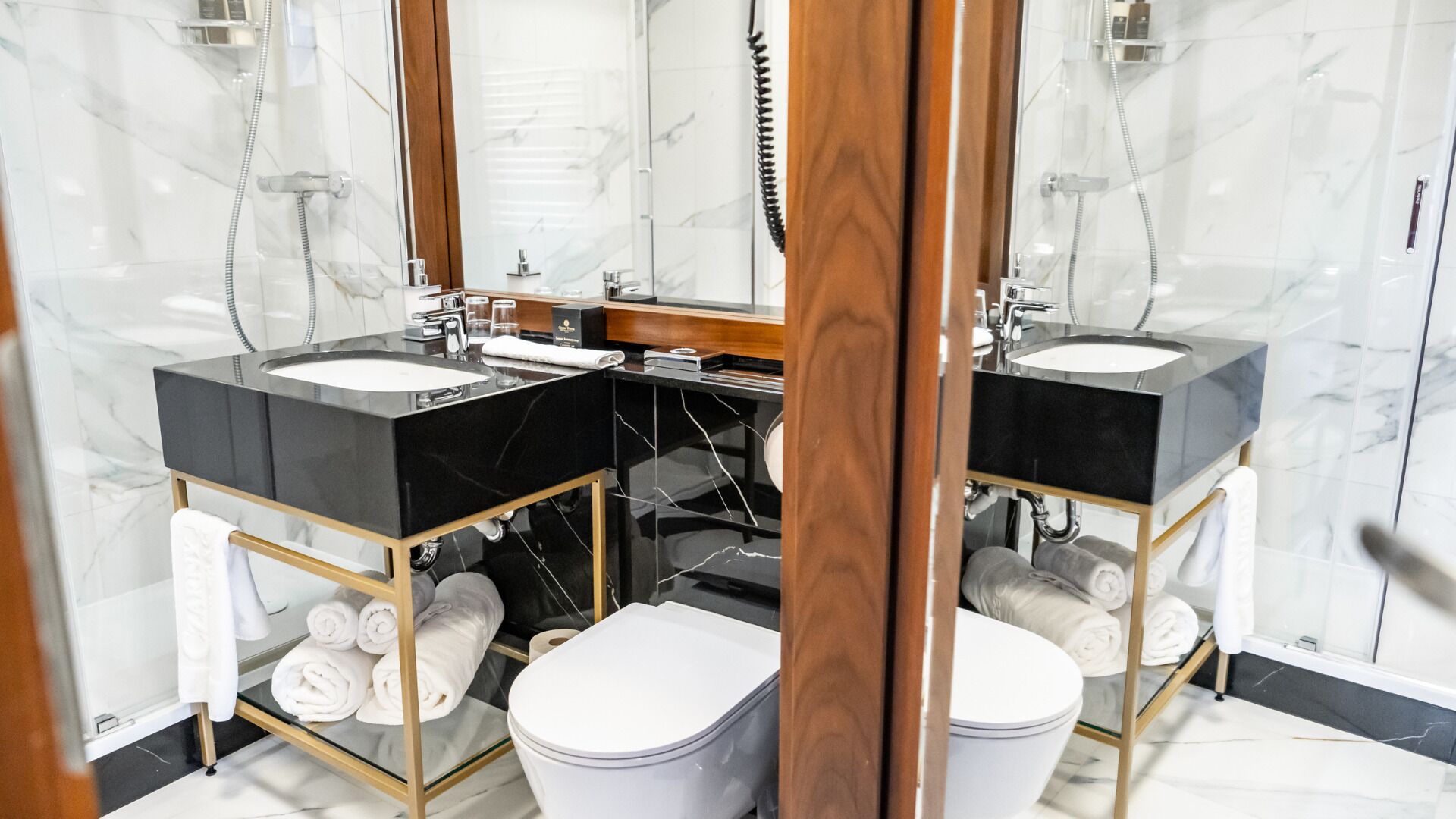 Un baño moderno con dos lavamanos, un inodoro y una ducha.