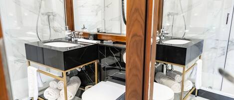 Un baño moderno con dos lavamanos, un inodoro y una ducha.