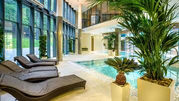 Relax by the pool surrounded by lush greenery and take in the views of the surrounding architecture.