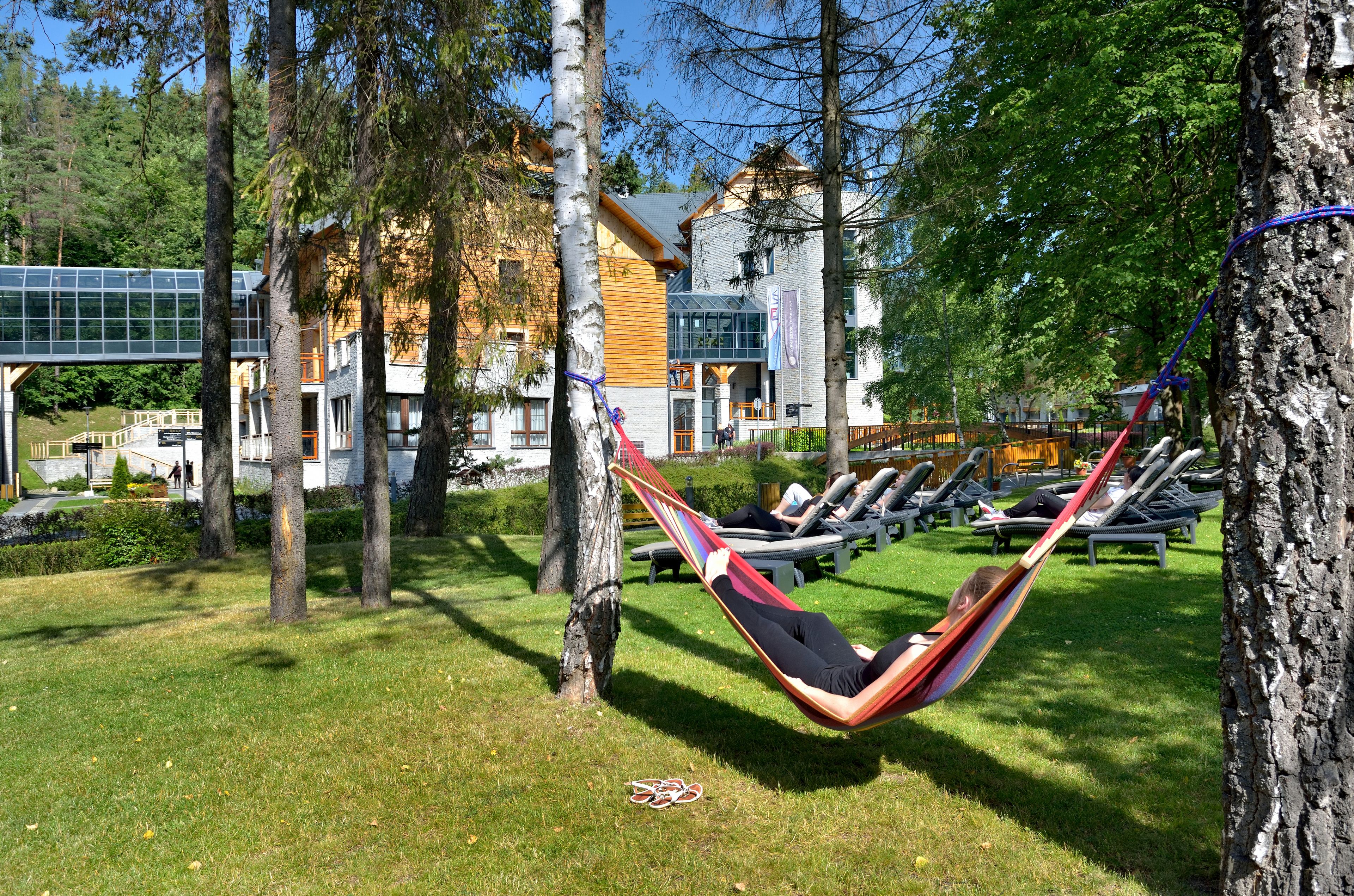 A hammock in a grassy area with a building in the background.