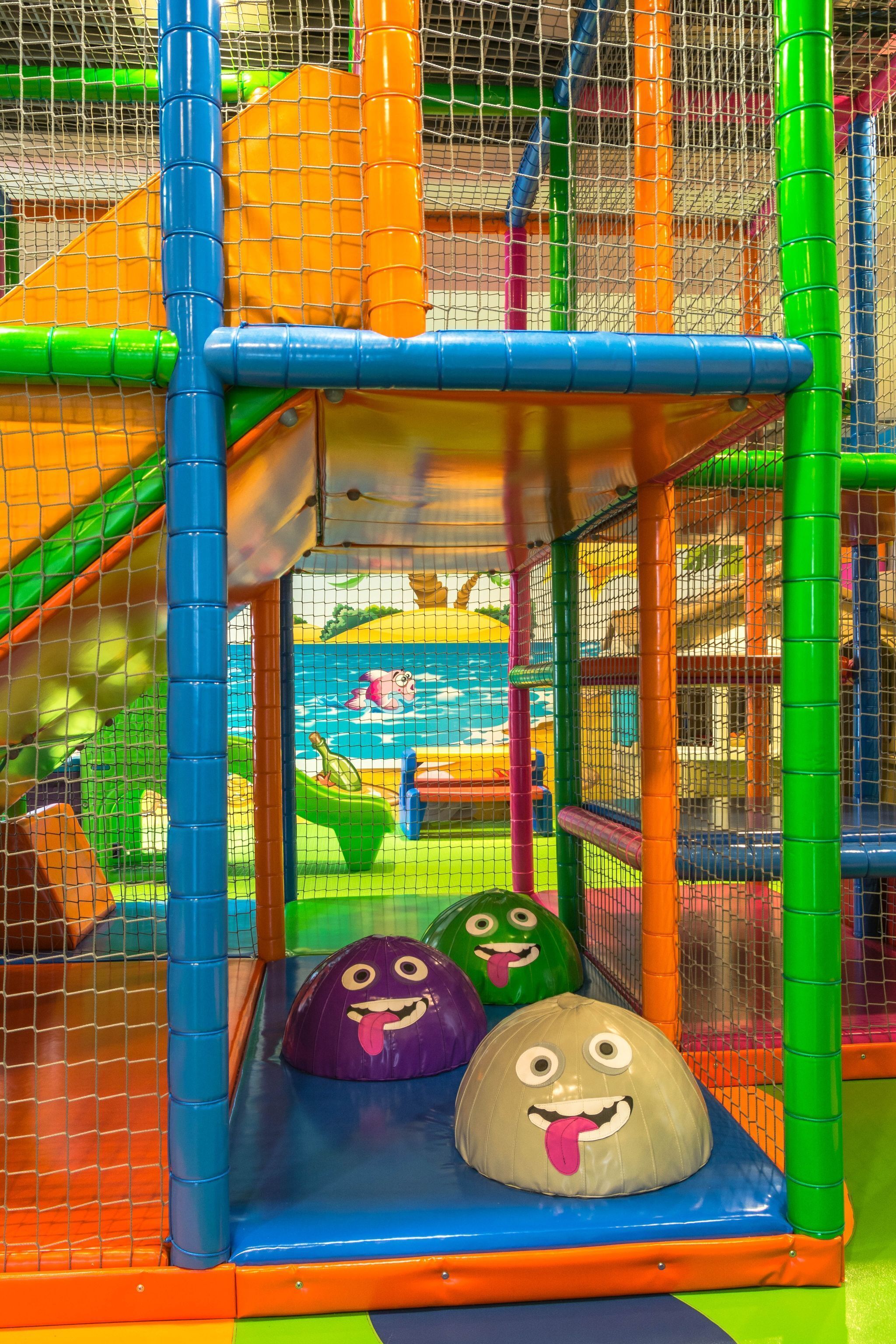 A children's play area with colorful play structures and soft play surfaces.