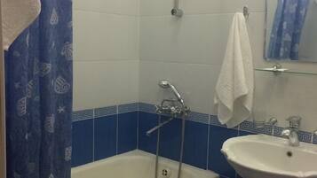 Une salle de bain avec une baignoire, un lavabo et une douche.
