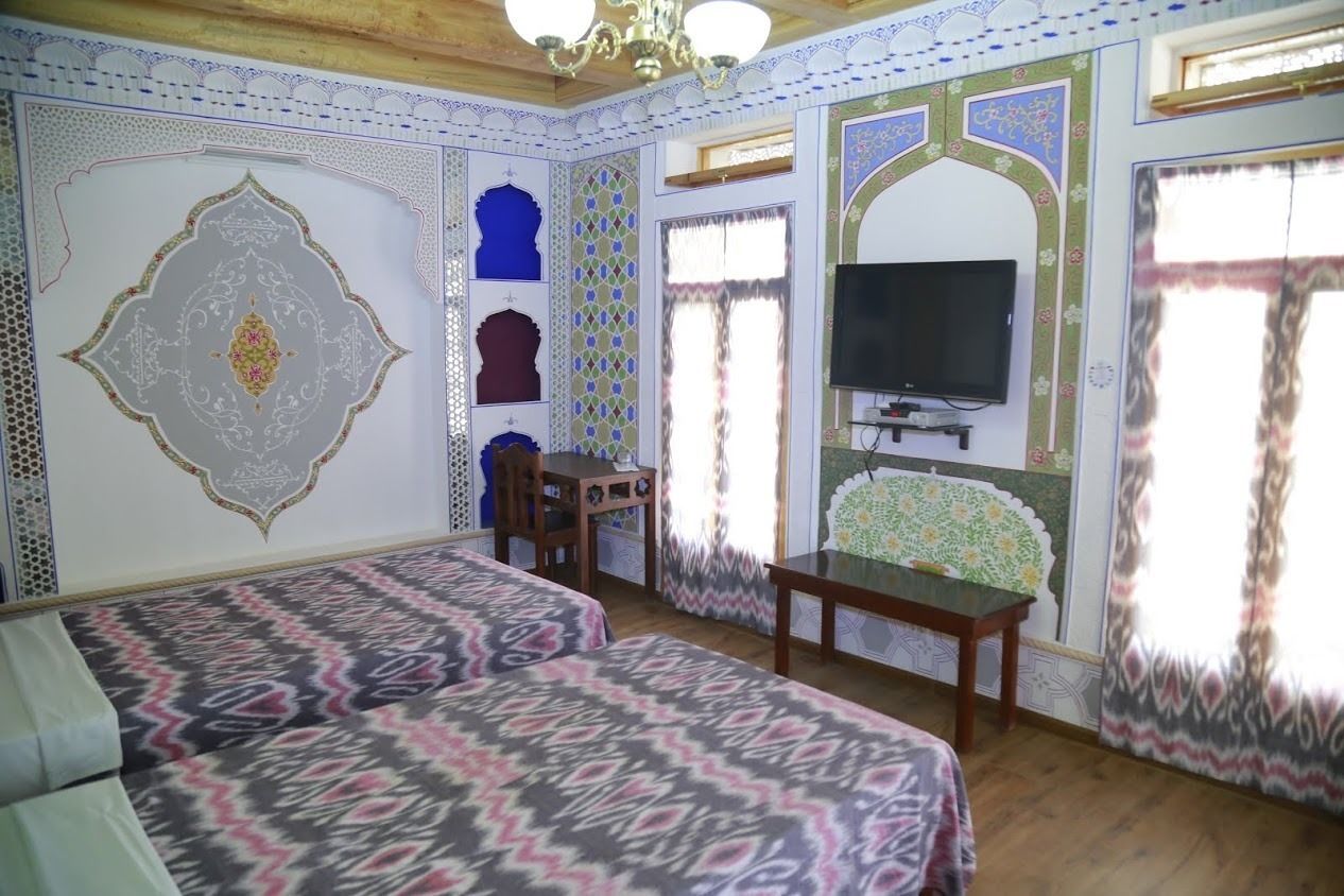 Una habitación con dos camas, un televisor y una mesita.