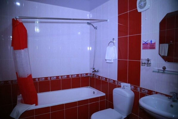 Un baño con bañera, inodoro y lavamanos.
