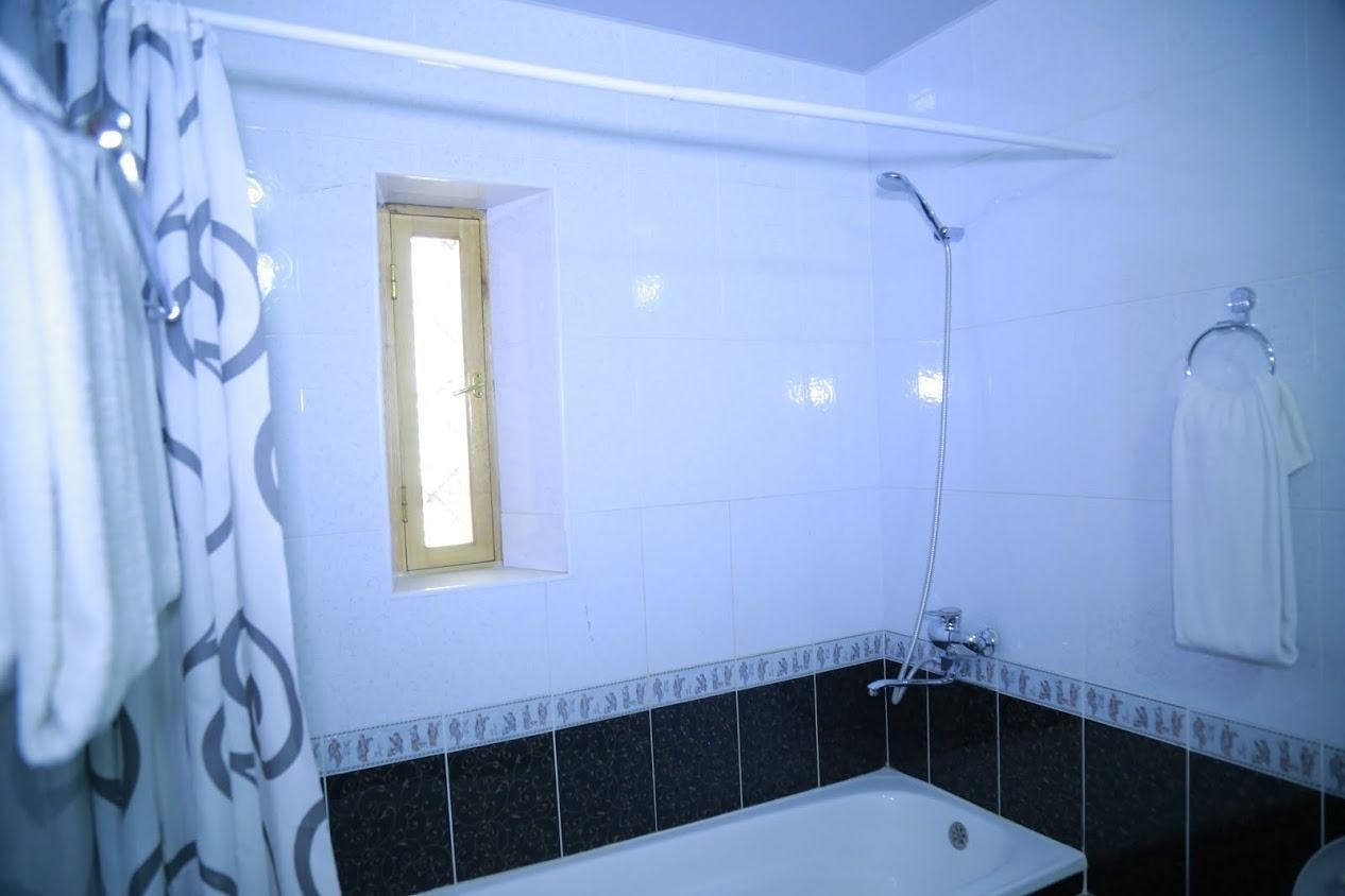 A bathroom with a bathtub, a shower, and a window.