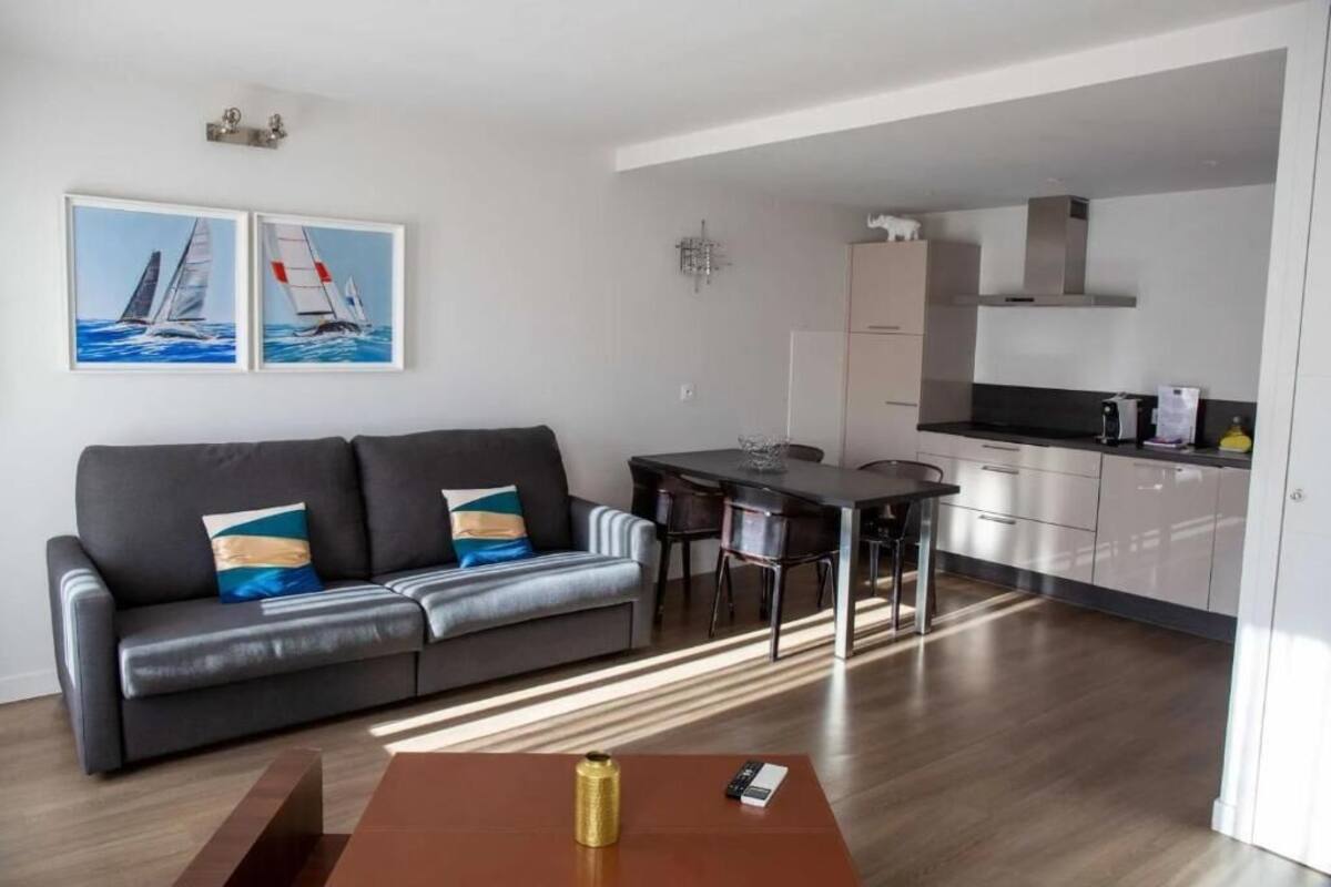 A modern living room with a sofa, coffee table, and artwork on the wall.