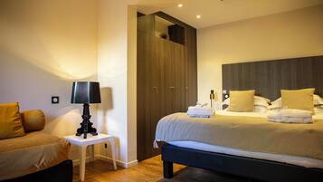 A bedroom with a bed, bedside table, lamp, and a mirror.
