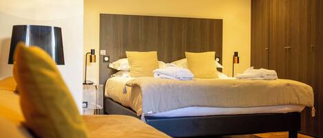 A hotel room with a bed, bedside tables, a lamp, and a wardrobe.