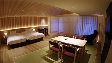 Habitación de hotel con cama, escritorio, silla y sillón de masaje.