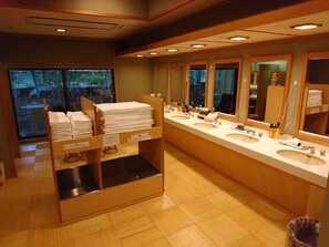 A public restroom with multiple sinks, mirrors, and a towel dispenser.