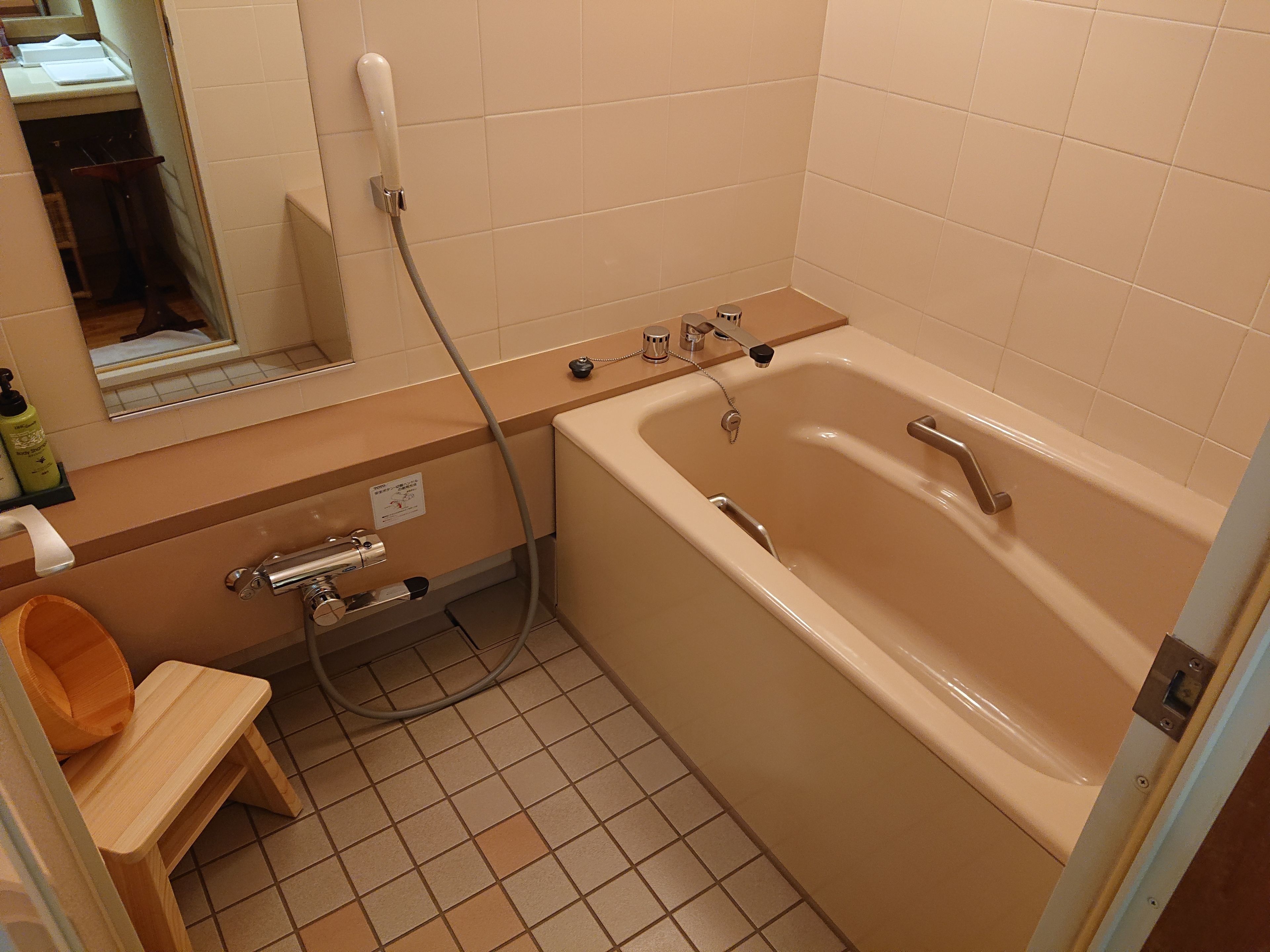 A bathroom with a bathtub, a shower, a sink, and a mirror.