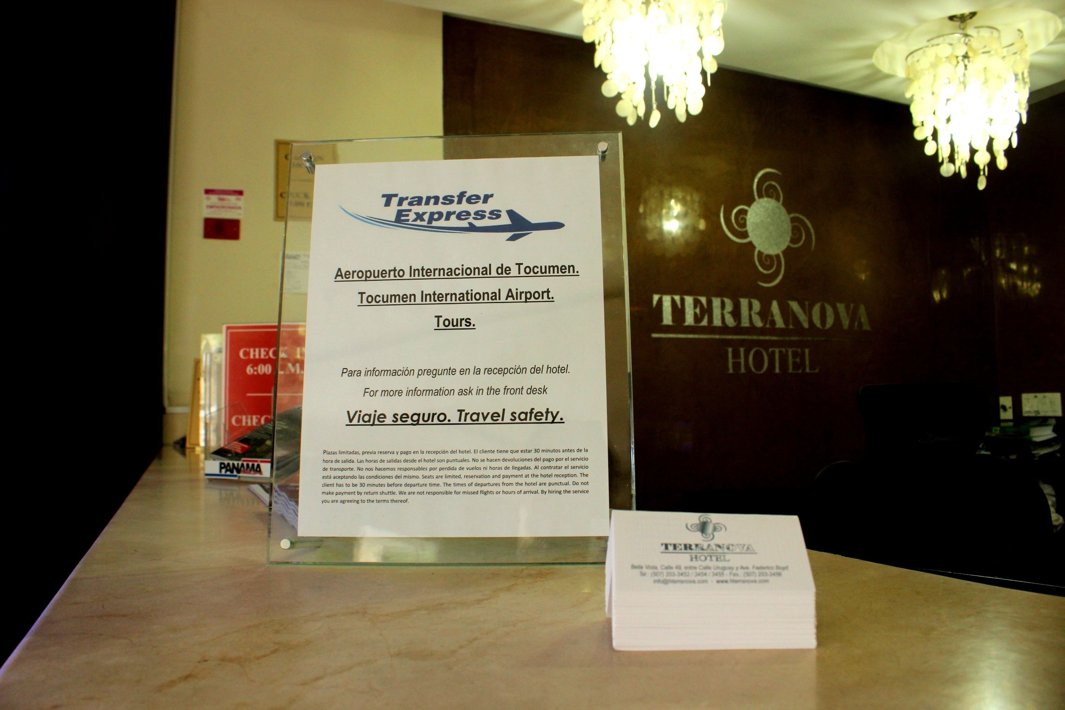 A reception desk with a sign for Transfer Express and a TERRANOVA HOTEL sign in the background.