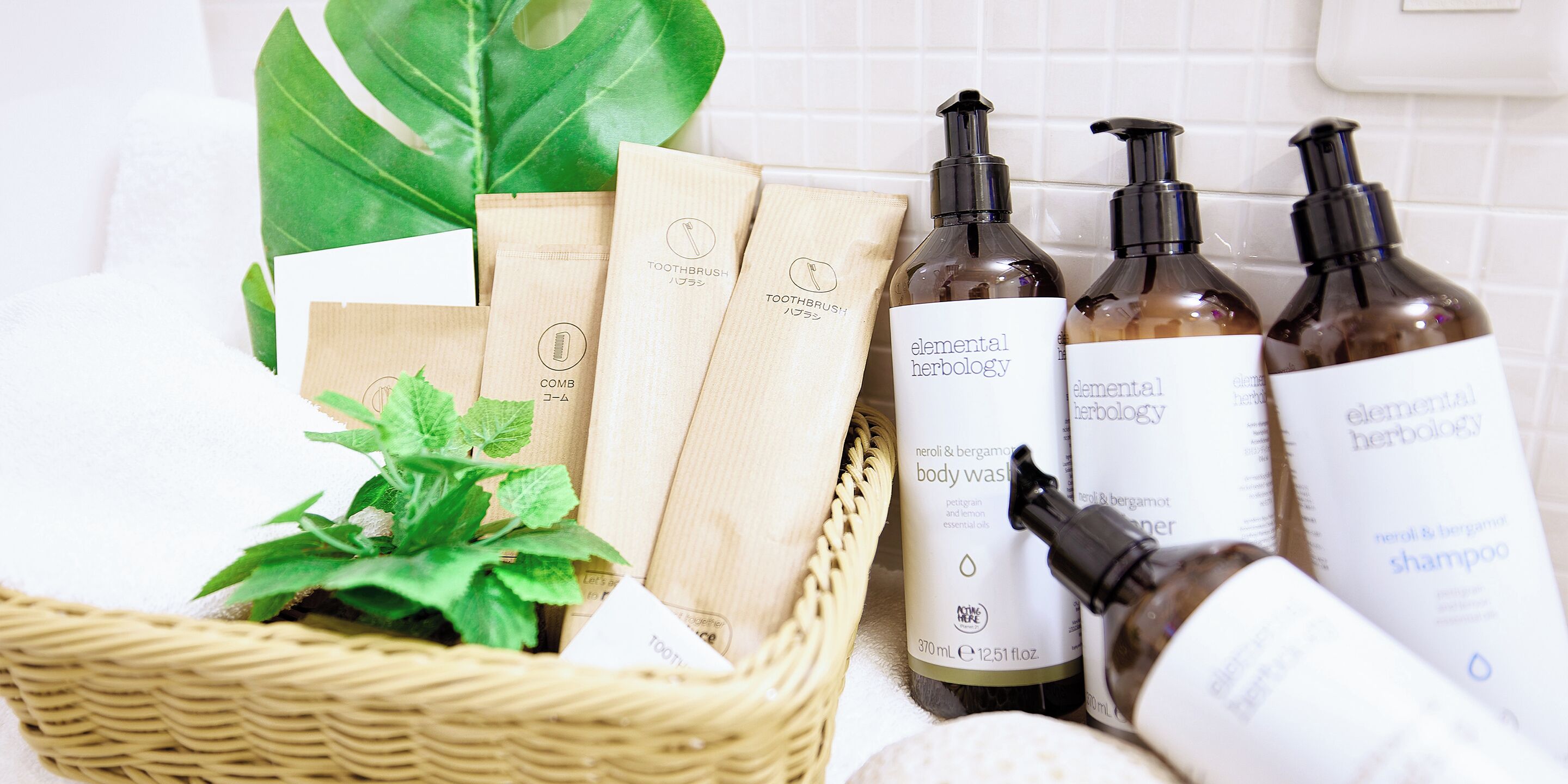 A basket with herbal products, including bottles and bags, and a green plant.