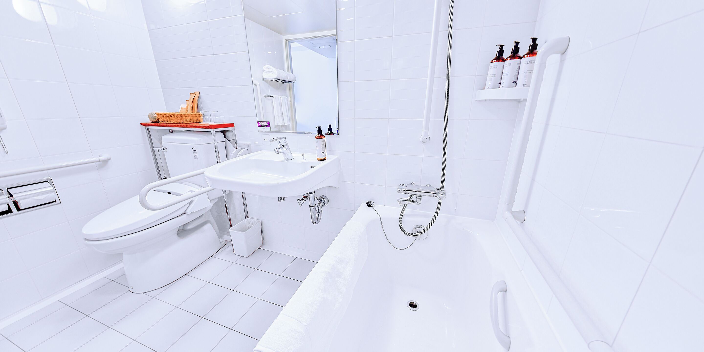 A modern bathroom with a toilet, sink, and bathtub.