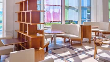 A modern indoor seating area with wooden furniture and a tiled floor.
