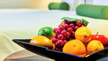 A fruit bowl with oranges, lemons, and grapes on a table.