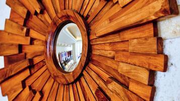 Un espejo de pared de madera con diseño de sol.
