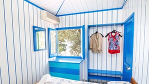 A room with a bed, a window, and a blue door.