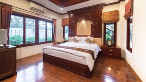 A spacious bedroom with a large bed, wooden furniture, and large windows. - Ruen Ariya Resort (Mae Rim)