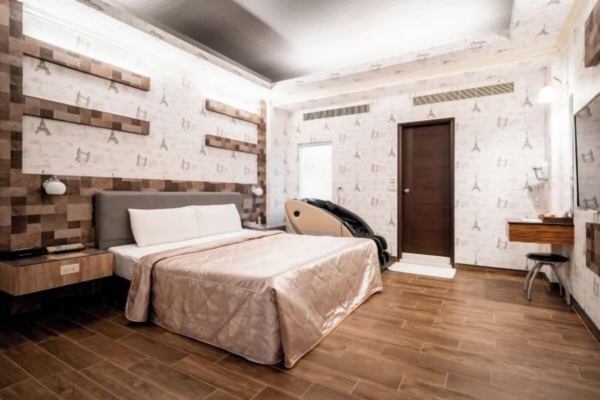 A bedroom with a bed, nightstand, and a wall with a pattern.