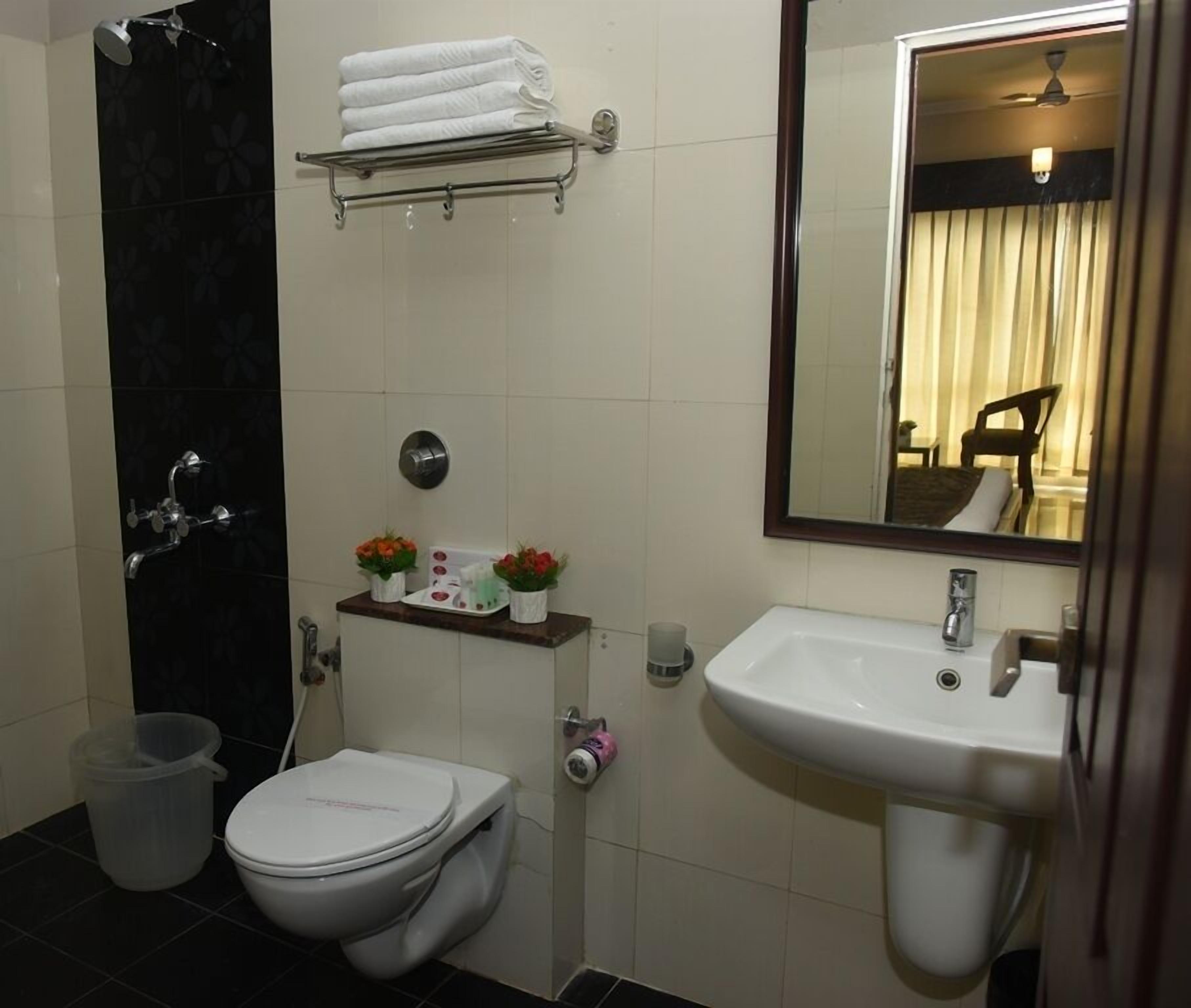 A compact bathroom with a toilet, sink, and shower.