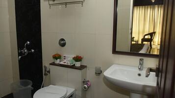 A compact bathroom with a toilet, sink, and shower.