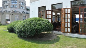 Un edificio con grandes ventanales y un pequeño jardín.