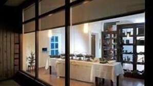 Un comedor con mesas y sillas, ventanas amplias y vista al interior.