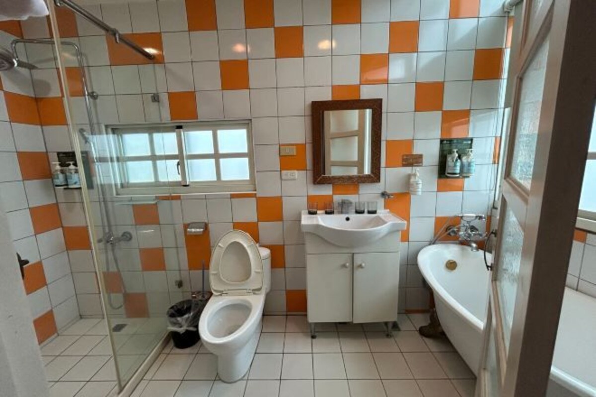 A bathroom with a glass shower enclosure, a toilet, a sink, and a bathtub.