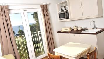 A compact kitchen with a dining area, a sink, and a microwave.