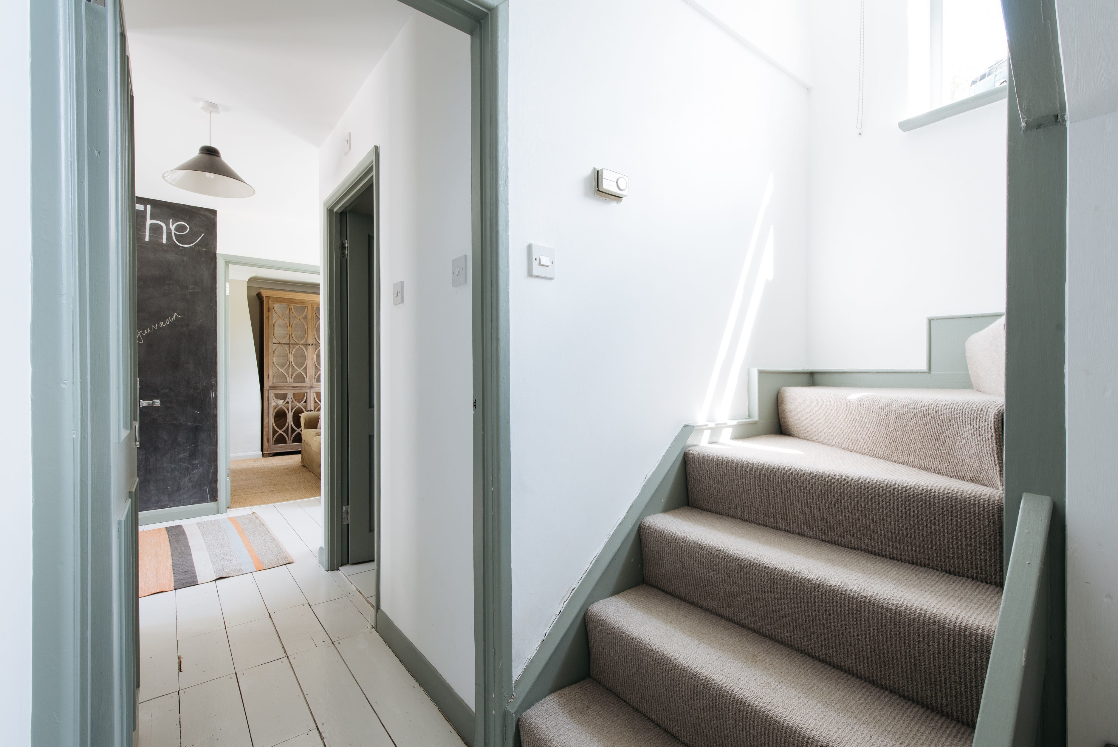 A staircase with beige carpeted steps leading to a landing.