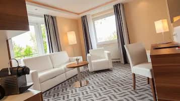 Ein Hotelzimmer mit einer Couch, einem kleinen Tisch, einem Schreibtisch und einer Lampe.