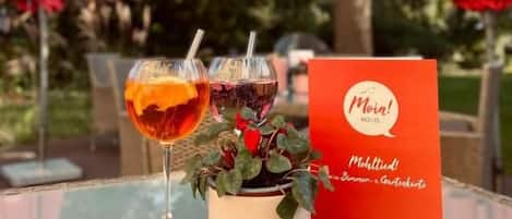 Una mesa de vidrio con dos bebidas y un cartel rojo con texto.