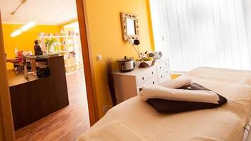 A hotel room with a bed, a dresser, a mirror, and a window with blinds.
