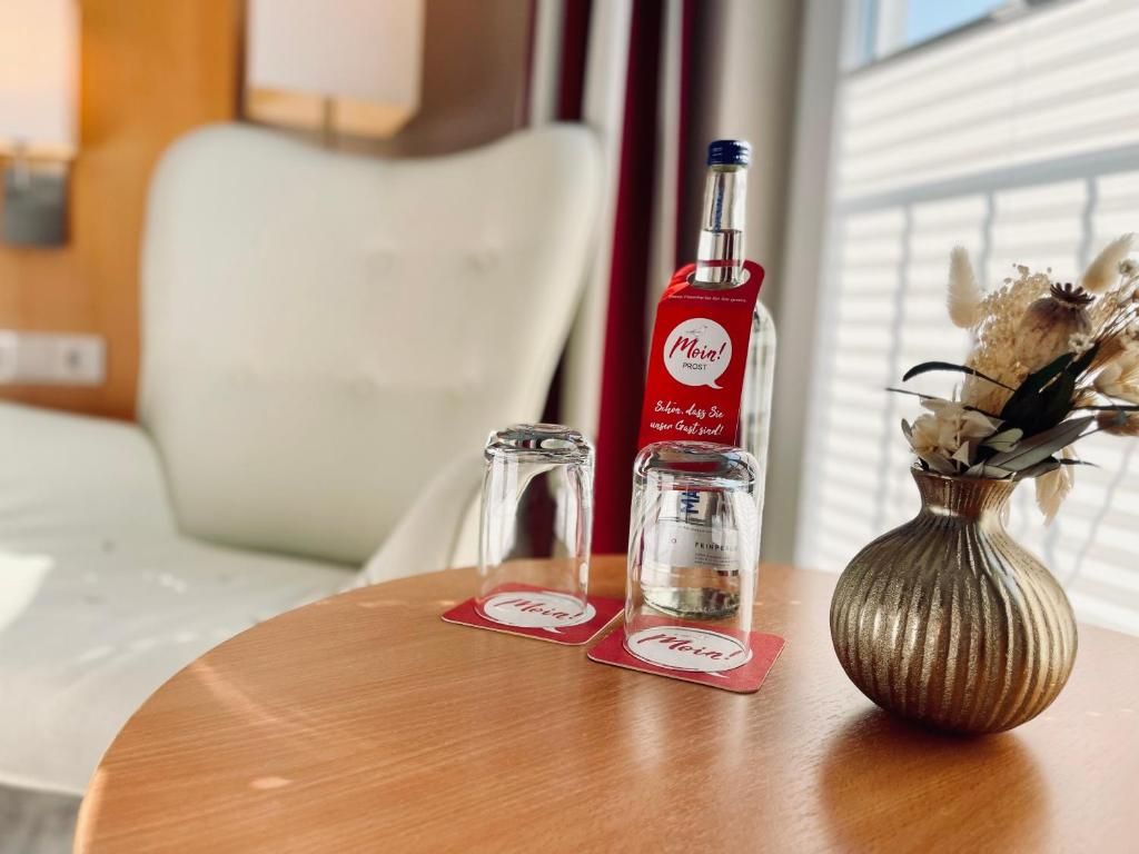 Ein Tisch mit einer Flasche Moët & Chandon Champagner, Salz- und Pfefferstreuern sowie einer Vase mit getrockneten Blumen.