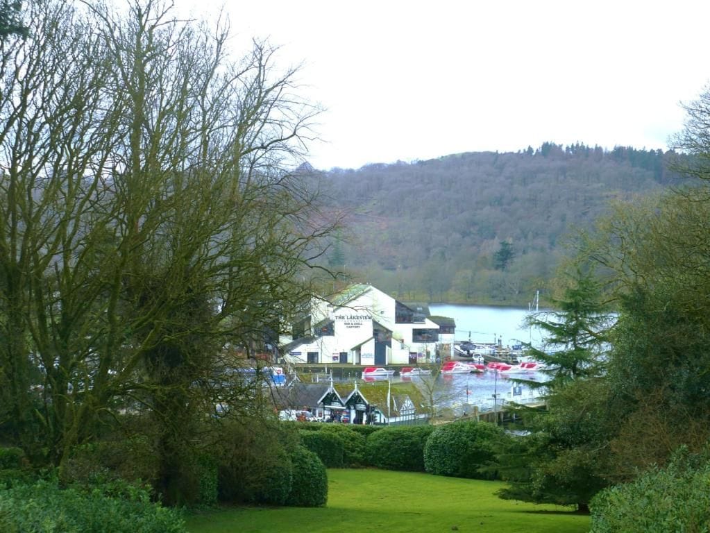 A building with a sign 'The Lakeview' in a natural setting with a body of water and hills in the background.