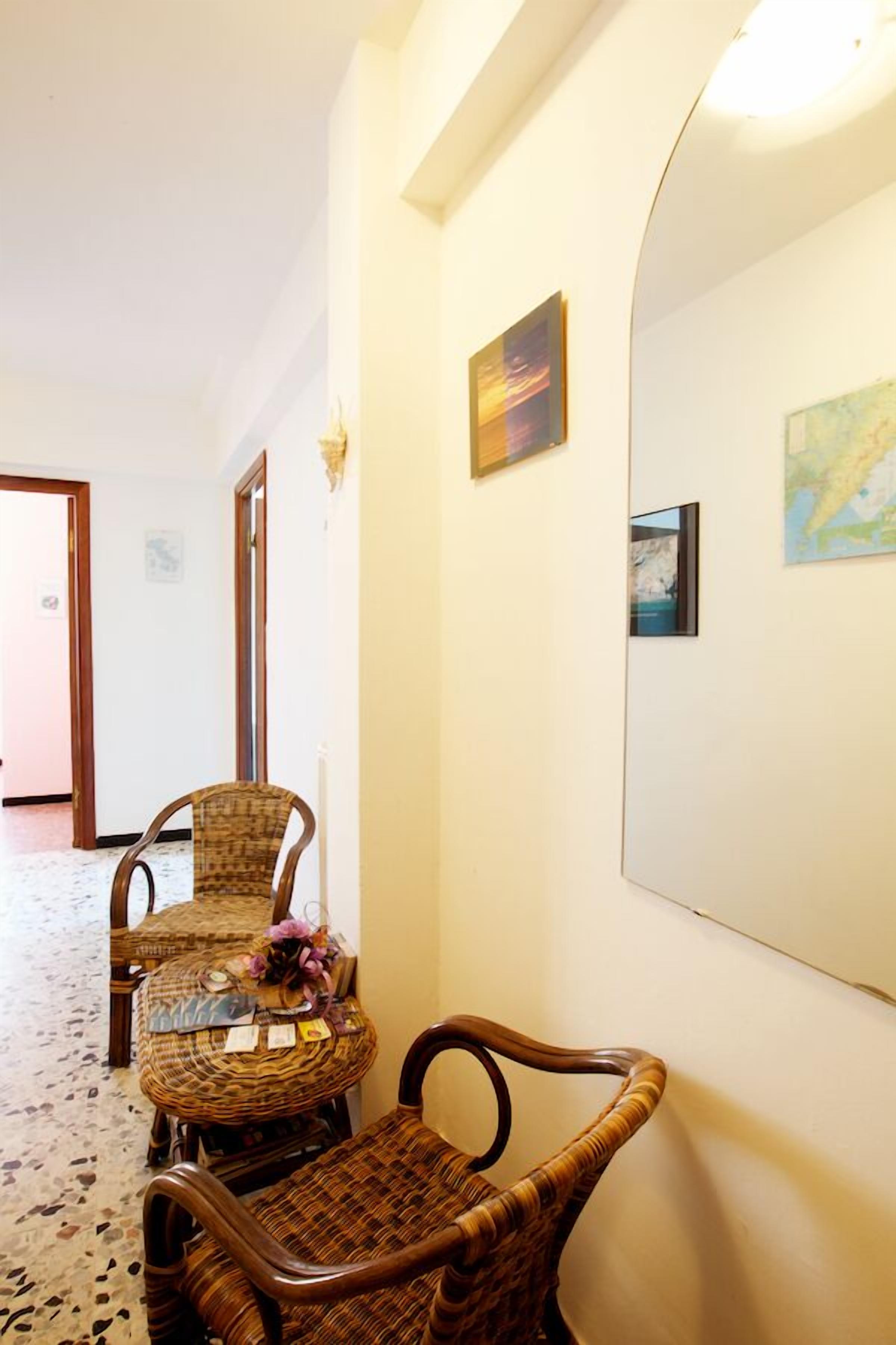 A hallway with wicker furniture and a large mirror.