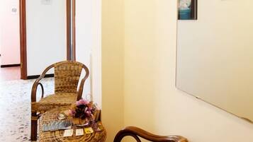A hallway with wicker furniture and a large mirror.